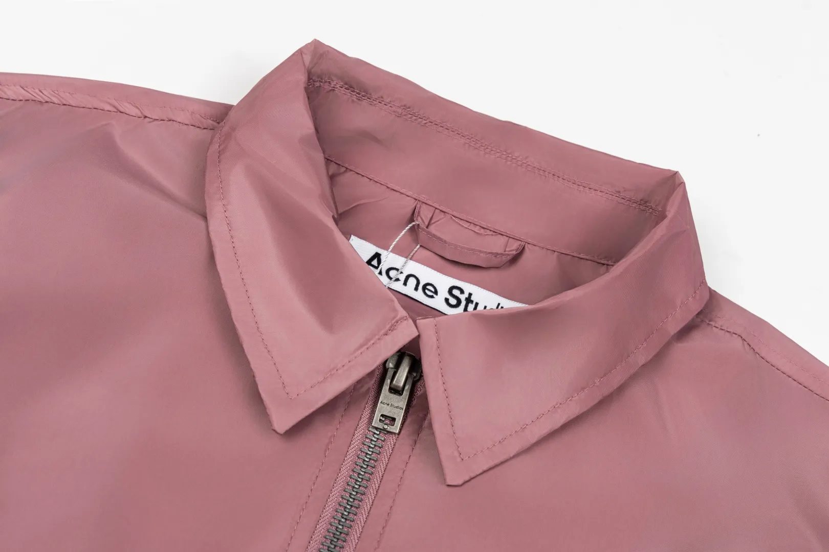 140 Acne Studios Lapel Coach Jacket Glossy nylon back lettering loose windproof jacket Classic lapel coach jacket version, STOCKHOLM back logo, Nordic simple style High-density glossy nylon fabric, light and crisp, windproof and water-repellent, with high-end gloss Metal main zipper + side eyelet details, cuff hem elastic cuffs, lock-type windproof Simple no large print on the front chest, letters on the back as a visual highlight, suitable for street commuting Style number: ST 014# Color: Off-white Black Burgundy Size: S-XL